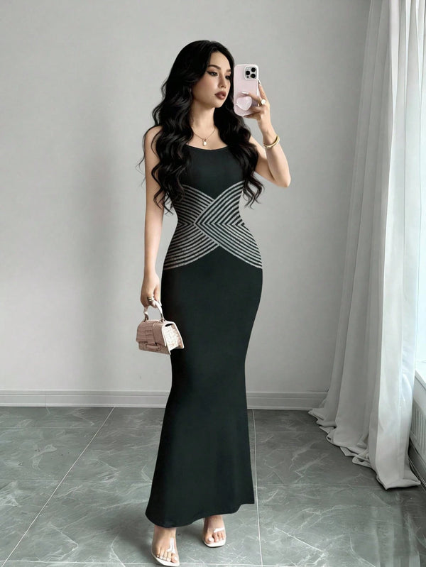 Woman taking a mirror selfie wearing a black and gray dress in a room with gray walls and white curtains.