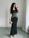 Woman taking a mirror selfie wearing a black and gray dress in a room with gray walls and white curtains.