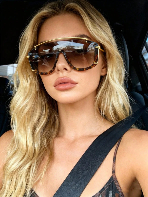 Woman wearing large sunglasses inside a vehicle