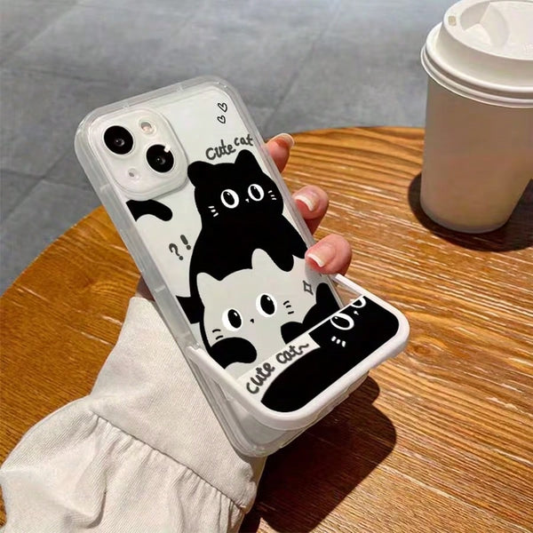 Phone case with a black and white cat design held by a person on a wooden table.