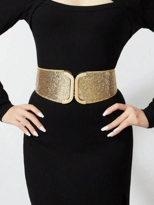 Person wearing a black dress with a gold belt on a white background