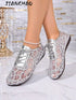 A pair of women's lace-up shoes with a silver glittery geometric mesh pattern, shown on a model's feet against a marble floor and decorative background. The brand name 'JIANCHAO' is visible in the top left corner.