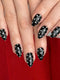 Close-up of hands with black nail polish featuring white polka dots on a red background