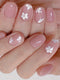 Nails with pink polish and white floral designs on a neutral background
