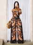 Woman wearing a patterned strapless jumpsuit taking a mirror selfie.