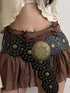Person wearing a decorative belt with large gold medallion and brown fabric