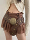 Brown skirt with decorative elements worn by a person on a plain background