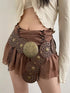 Brown skirt with decorative elements worn by a person on a plain background