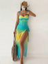 A woman takes a mirror selfie wearing a sleeveless gradient maxi dress with a yellow-to-blue color transition, a cowboy hat, and holding a woven tote bag.