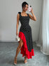 Woman taking a mirror selfie wearing a black and white polka dot dress with a red bottom half.