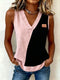 Person wearing a two-tone pink and black sleeveless top with blue jeans on a plain background