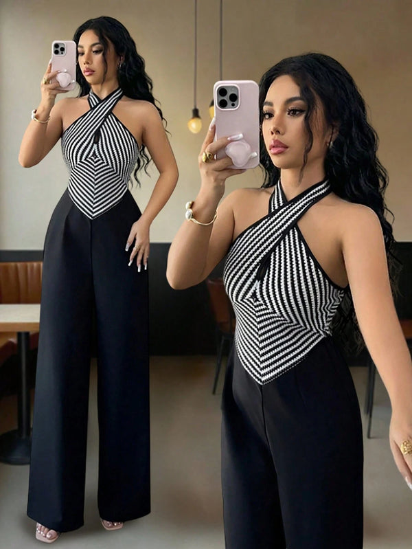 A woman takes a mirror selfie wearing a sleeveless halter-style jumpsuit with a black and white striped geometric bodice and wide black legs. A second, larger view of the same outfit appears in the mirror background, showing the full length.