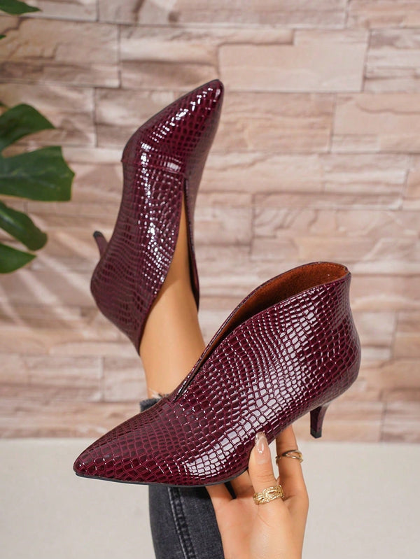 Burgundy crocodile-patterned high heels on a neutral background