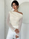 Woman wearing a white off-shoulder top with sheer sleeves against a light background