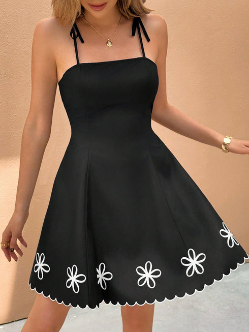 Black dress with white floral details on a beige background