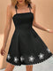 Black dress with white floral details on a beige background