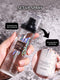 Makeup spray bottle held by a hand with text indicating setup spray features.