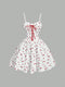 White dress with red floral pattern and lace-up front on a gray background