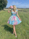 Woman in a colorful dress holding flowers in a field