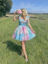 Woman in a colorful dress holding flowers in a field