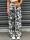 Person wearing camouflage pants and white sneakers standing in front of a metallic shutter.