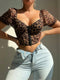 Person wearing a leopard print top and light blue jeans against a neutral background