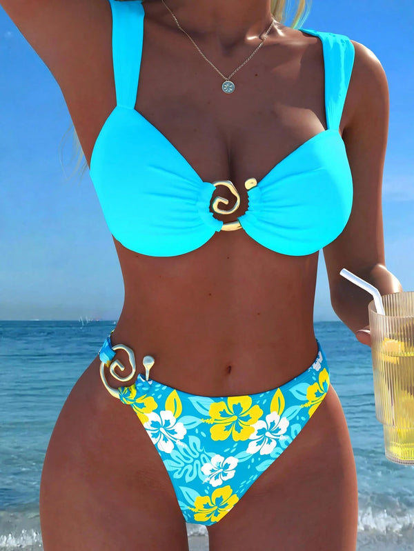 Person wearing a blue bikini with floral design against a beach background