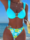 Person wearing a blue bikini with floral design against a beach background