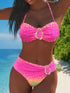Woman wearing a pink bikini with gold buckles on a beach