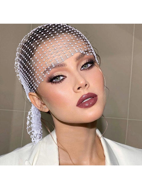 Woman wearing a decorative headpiece with a neutral background