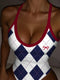 A close-up of a woman wearing a one-piece swimsuit with a white base, navy blue argyle diamonds, and red trim, including a small red bow detail on the chest.