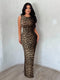 Woman wearing a leopard print dress against a plain background
