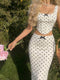 Woman in a polka dot dress holding flowers outdoors