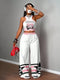 Person wearing a white and pink outfit with 'New York 23' design, holding a red bag.