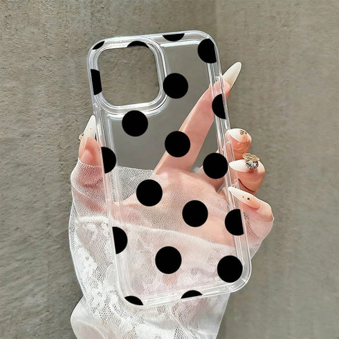 Clear phone case with black polka dots held by a hand against a neutral background