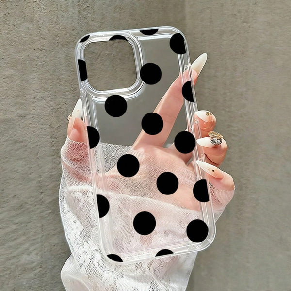 Clear phone case with black polka dots held by a hand against a neutral background