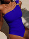 Woman wearing a blue one-shoulder swimsuit on a sandy background