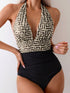 One-piece swimsuit with geometric patterned top and black bottom on a plain background