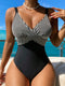 Woman wearing a black and white striped swimsuit with a scenic background