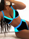 Person wearing a black and blue bikini with a neutral background