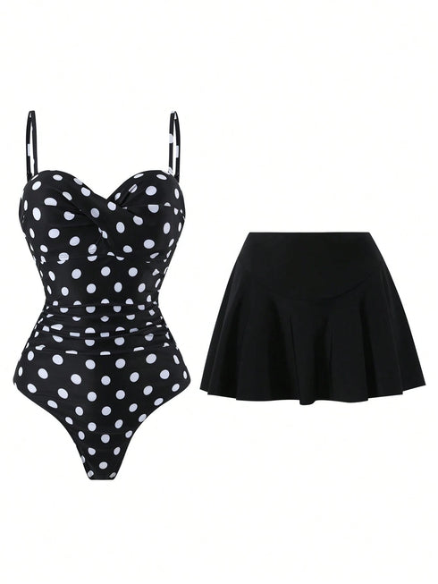 A two-piece swimsuit set featuring a black one-piece swimsuit with white polka dots and a solid black pleated mini skirt, displayed against a plain white background.