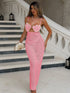 Woman in a pink crochet dress standing on a staircase