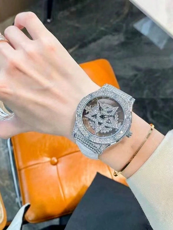 Close-up of a wrist wearing a diamond-encrusted watch with a blurred background