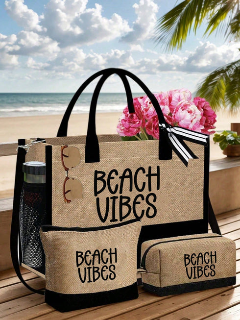 A beige burlap-style beach tote bag with black handles and trim, plus matching pouches, set on a wooden deck with a beach and ocean background. The bags are printed with the words “BEACH VIBES” in black and decorated with pink flowers and sunglasses.