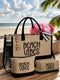 A beige burlap-style beach tote bag with black handles and trim, plus matching pouches, set on a wooden deck with a beach and ocean background. The bags are printed with the words “BEACH VIBES” in black and decorated with pink flowers and sunglasses.