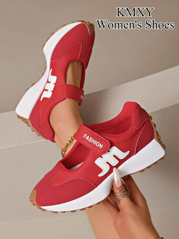 A pair of red women's platform sneakers with white side logos and a white strap, shown being worn and held by a hand against a beige background. Text in the top right reads 'KMXY Women's Shoes'.