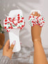 White sandals with red cherry pattern worn by a person on a blurred background