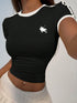 Black crop top with a white logo worn by a person against a neutral background