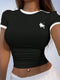 Black crop top with a white logo worn by a person against a light blue background
