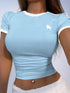 Light blue crop top with a white logo worn by a person against a neutral background